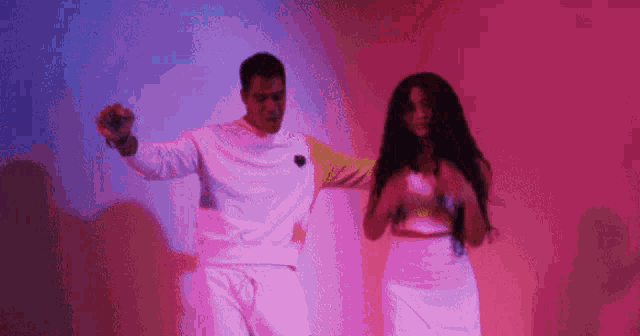 a man and a woman are dancing in front of a pink background