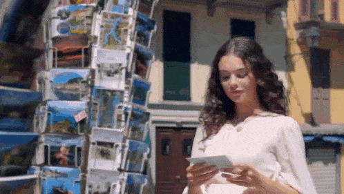 a woman is looking at a postcard that says " italy " on it