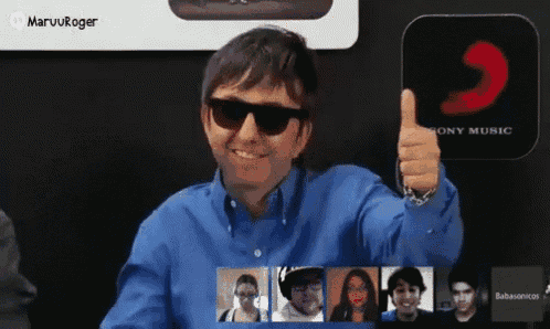 a man wearing sunglasses is giving a thumbs up in front of a sony music sign