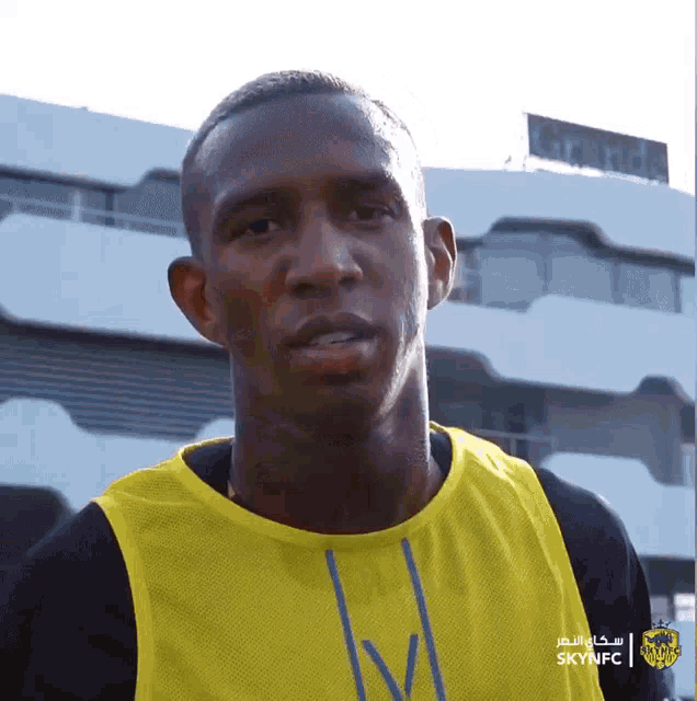 a man wearing a yellow and black shirt that says skynfc on it