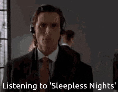 a man in a suit and tie wearing headphones says listening to sleepless nights