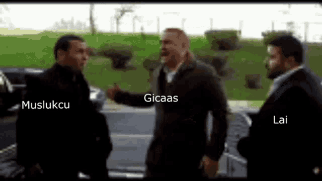 a group of men are standing next to each other in front of a car and talking .