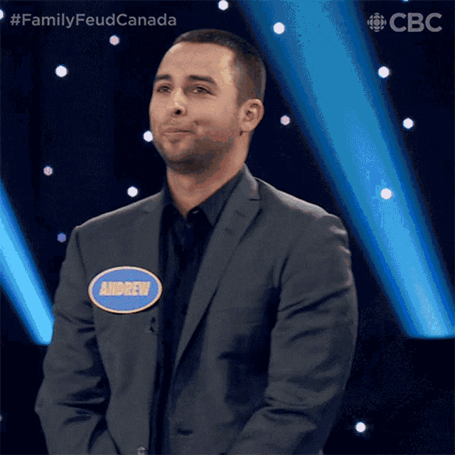 a man in a suit with the name andrew on his jacket