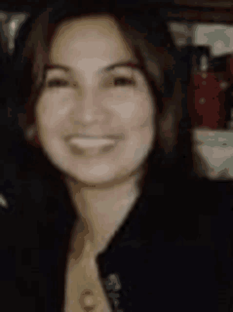 a close up of a woman 's face smiling in a black jacket .