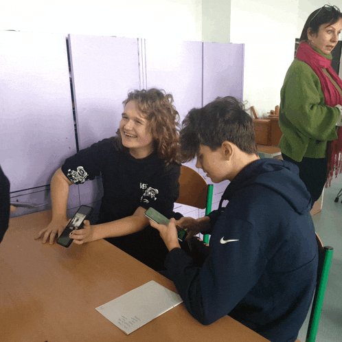a boy wearing a nike sweatshirt sits at a table