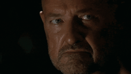 a man with a beard says " thank you " in a dark room