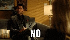 a man in a suit is sitting on a couch with the word no on the couch