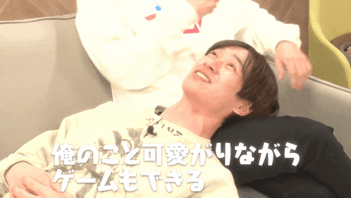 a man laying on a couch with a foreign language behind him
