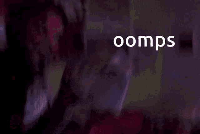 a bed with a purple blanket and the word oomps on the bottom