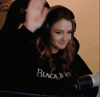 a woman wearing headphones and a black shirt that says black jesus on it