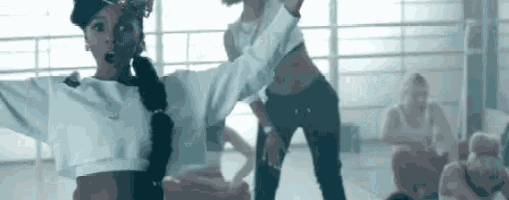 a woman is dancing in a room with other people .