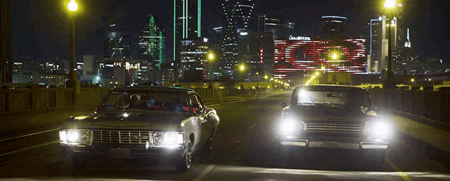 two cars are driving down a highway at night with a building in the background that has the word southern on it