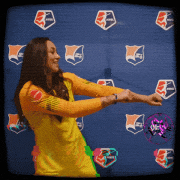 a woman in a yellow shirt is dancing in front of a wall that says nwpsl