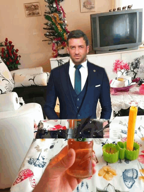 a man in a suit and tie is holding a glass in front of a tv