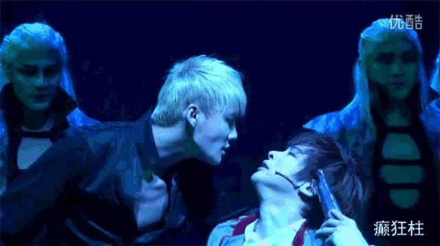 a man is kissing another man on the neck with chinese writing on the bottom