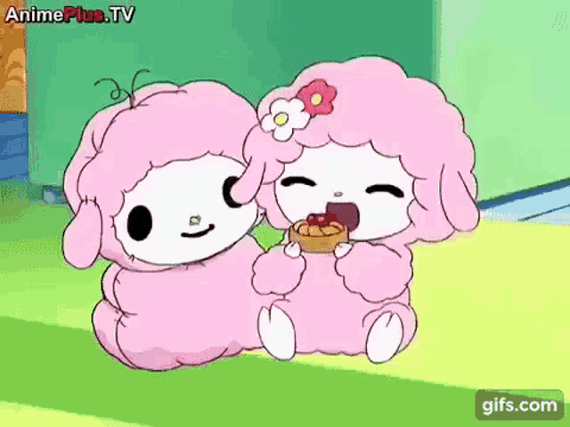 a couple of pink sheep are sitting next to each other eating a cake .