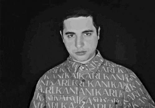 a black and white photo of a man with a shirt that says ' ari kani ' on it