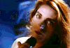 a woman is singing into a microphone in a close up of her face .