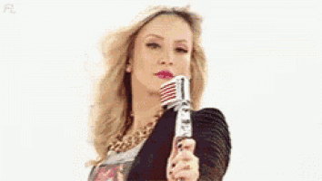 a blonde woman is holding a microphone in her hand .
