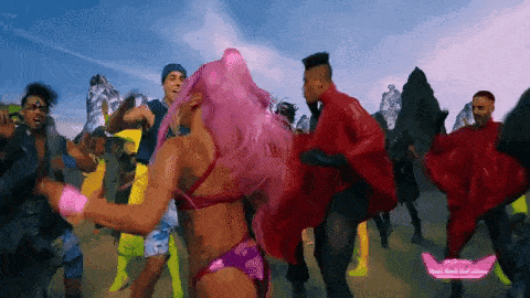 a woman with pink hair is dancing with a group of men .