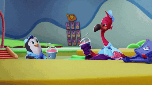 a penguin and a flamingo are sitting at a table with a drink