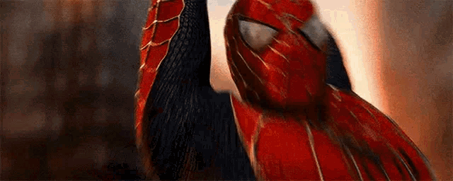 a close up of a person in a spiderman costume holding up their hand .