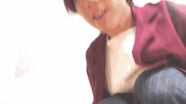 a close up of a person wearing a red jacket and jeans .
