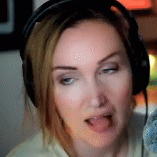 a woman wearing headphones is sticking out her tongue .