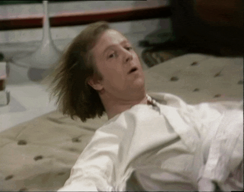 a man is laying on a bed with his eyes closed