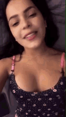 a woman in a polka dot top is taking a selfie