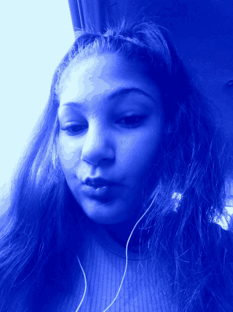 a girl with long blue hair looks at the camera