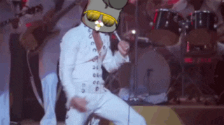 a man in a white suit is dancing on a stage with drums in the background