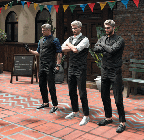 three men are standing in front of a sign that says menu