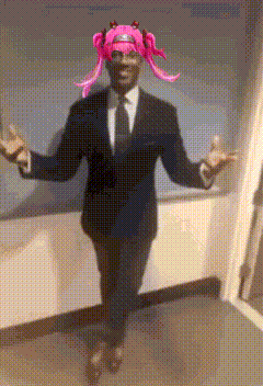 a man in a suit and tie with pink hair