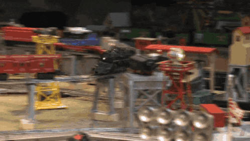 a blurred image of a toy train set with a red train on the right