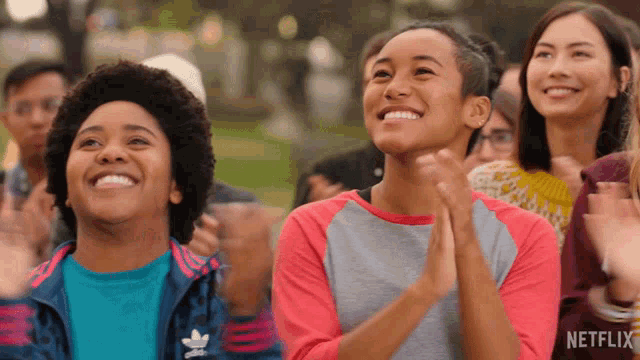 a group of people are clapping and smiling with a netflix logo in the corner