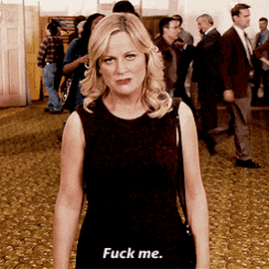a woman in a black dress says " fuck me " in front of a crowd