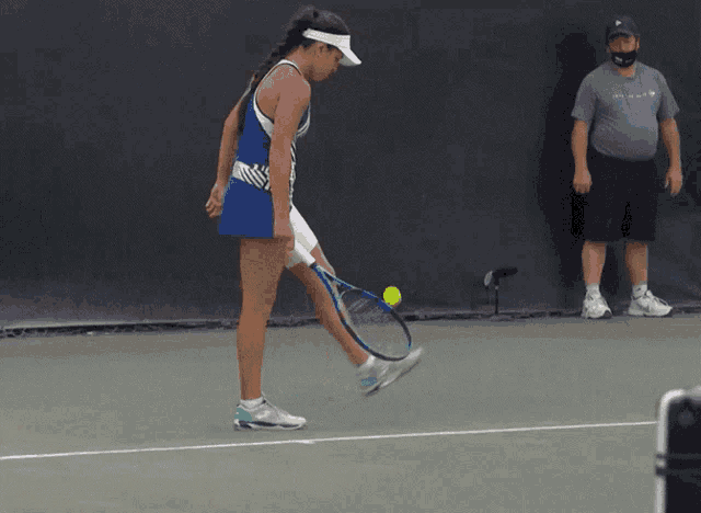 a woman holding a tennis racket on a tennis court