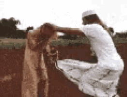 a woman in a white dress is kneeling down next to a man in a white hat