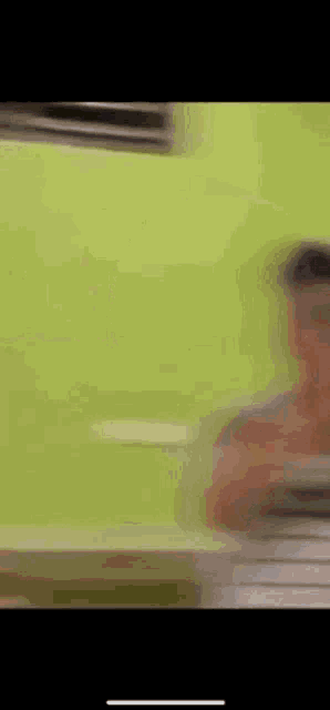 a blurry picture of a man holding a plate in front of a green background .