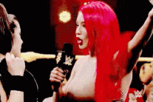 a woman with red hair is holding a microphone while talking to a man .