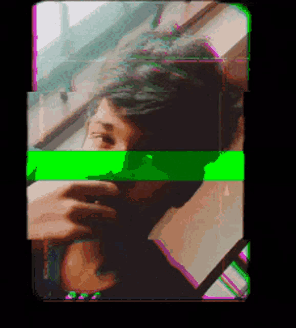 a man is looking out a window with a green and pink stripe across his face