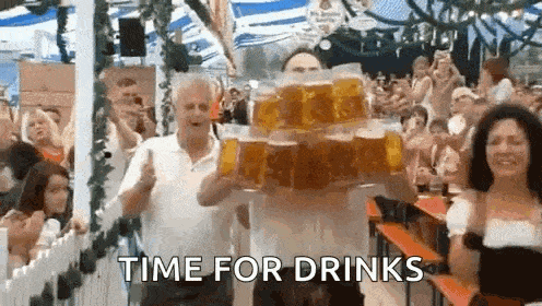 a man is carrying a stack of beer mugs in front of a crowd at a beer festival .