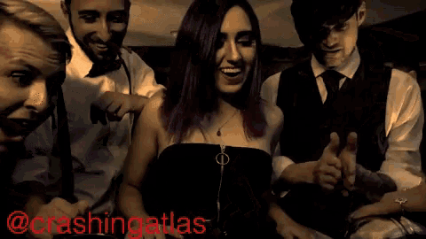 a woman with purple hair is standing in a crowd with the words crashingatlas on the bottom right