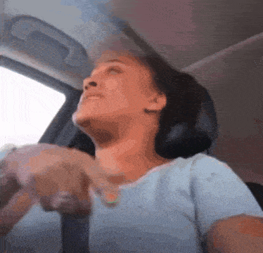 a woman is sitting in a car looking up