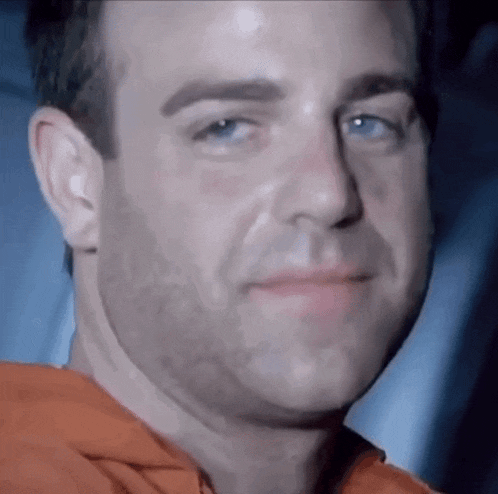 a close up of a man 's face with a beard and blue eyes .