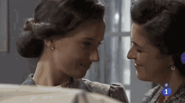 two women looking at each other with the number 1 on the bottom left