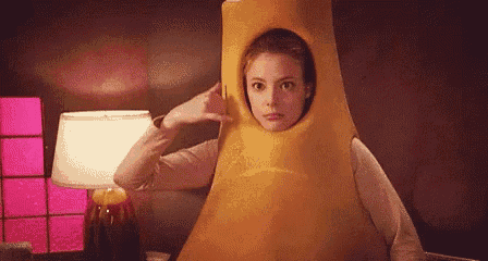 a woman is wearing a banana costume with a hole in the middle of her head .