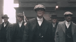 a group of men in suits and hats are standing next to each other on a city street .