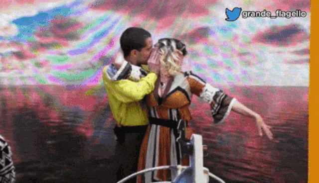 a man kissing a woman in front of a colorful background with grande flagello on the bottom
